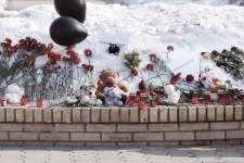 Над мемориалом развеваются два черных траурных шара, с утра сюда несут цветы